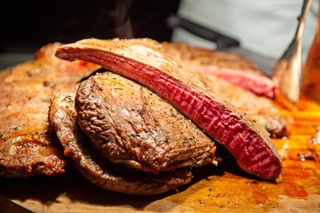 Oven roasted Flank steak on a cutting board. Cook to perfection. Medium rare, juicy and tender beef. Good for party,Thanksgiving,Christmas and New Year celebration. Festive holiday and season greeting