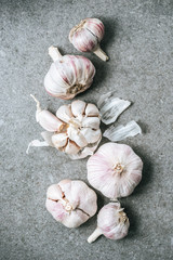 Top view of ripe garlic bulbs and husk on grey background