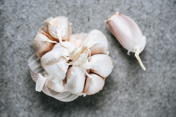 top view of peeled ripe garlic bulb on grey background