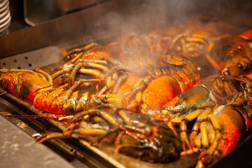 Sizzling hot cooking on the griddle pan. Delicious grilled halved Lobster with butter. Fresh, juicy and tasty Maine Lobster or American lobster. Sweet and flavorful lobster. Rich in omega-3 fatty acid
