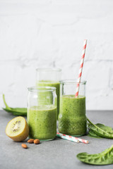 Green and healthy organic smoothie in glasses with straws