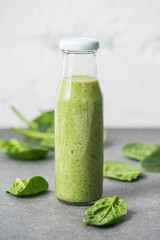 Green blended organic smoothie in glass bottle