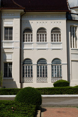 The front of a palace in Thailand with beautiful windows and ornamental elements.