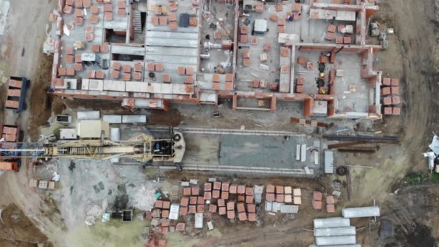 4k Bird's eye view of building a house from scratch. Tower cranes, building slabs.