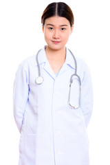 Studio shot of young beautiful Asian woman doctor with hands on 