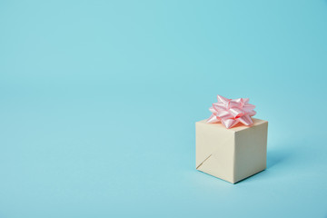 Gift box with pink bow on blue background