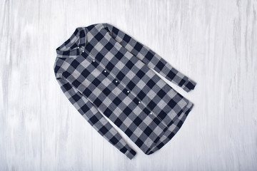 Checkered shirt on wooden background. Fashionable concept