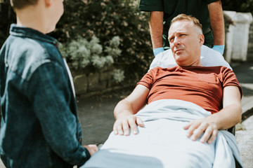 Paramedics moving a patient on a stretcher to an ambulance