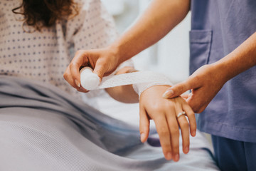 Nurse bandaging the patients arm