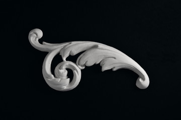 Stucco white acanthus leaf on a black background.