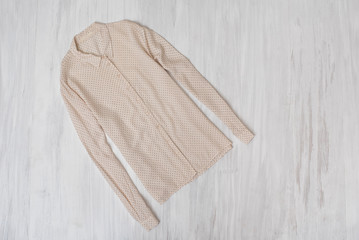Fashionable concept. Delicate beige blouse on a wooden background. Female wardrobe