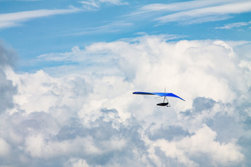 Fototapeta na wymiar Light aircraft, deltaplane, against the sky with white clouds. deltaplane