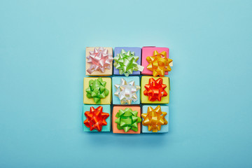 Top view of colorful gifts with bows on blue background