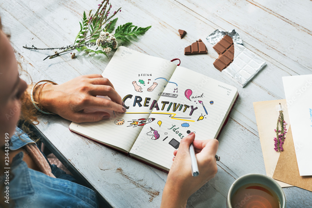 Wall mural young creative woman drawing in a notebook