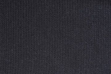 Black knitted fabric. Close up. Fashionable concept
