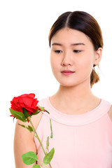 Close up of young beautiful Asian woman holding and looking at r