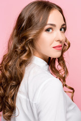 Happy business woman standing and smiling isolated on pink studio background. Beautiful female half-length portrait. Young emotional woman. The human emotions, facial expression concept