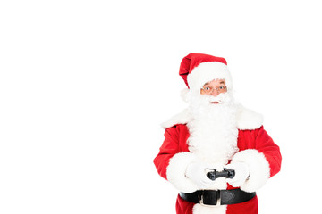 Fototapeta na wymiar santa claus playing video game with gamepad and looking at camera isolated on white