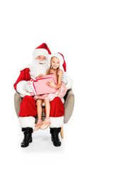 santa claus and little child sitting in armchair together and holding gift box isolated on white