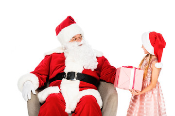 santa claus sitting in armchair and giving present to little child isolated on white
