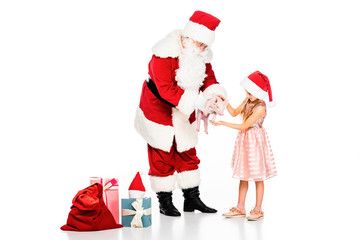 santa claus giving piggy to little child isolated on white