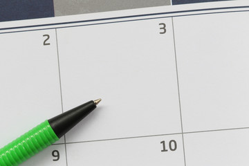 Green Pen pointed to the empty calendar of the third day and have copy space.