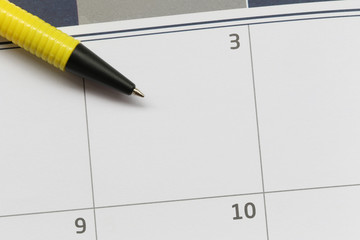Yellow Pen pointed to the empty calendar of the third day and have copy space.