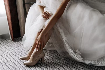 Foto op Plexiglas Beautiful legs of the bride in a wedding dress © Anntuan