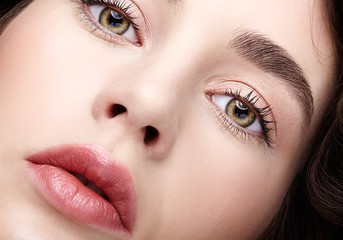 Naklejka premium Closeup beauty macro face portrait of young woman. Brunette girl with day nude female makeup