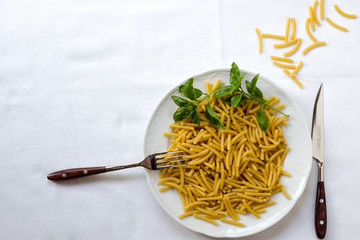 Nudelgericht ungekocht auf weissem Tischtuch