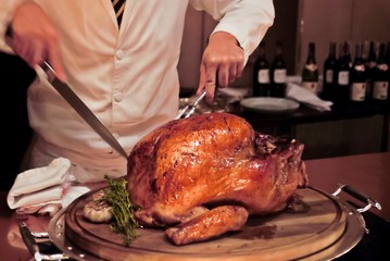 Professional chef carves a whole, roasted Turkey. An impressive centerpiece for family party,...