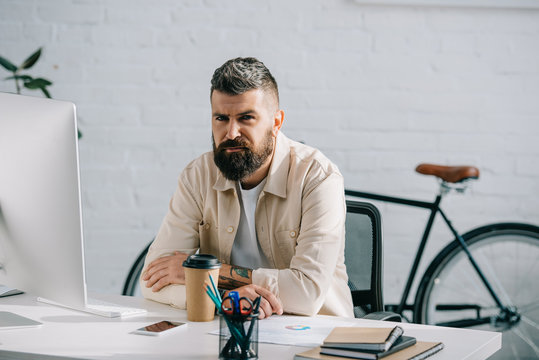 serious businessman sitting at desk in modern office
