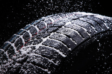Winter Car tires with snow on black background