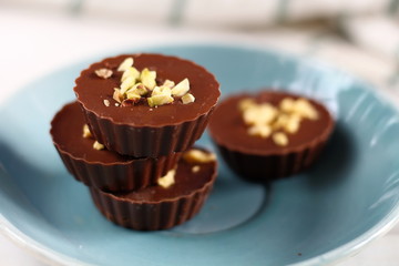 Milk chocolate cup candys with pistachio on the blue plate