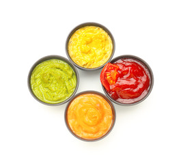 Different tasty sauces in bowls on white background