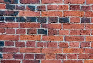 Naklejka premium Brick wall close-up texture photo. Vintage textured surface with old red-black brickwork