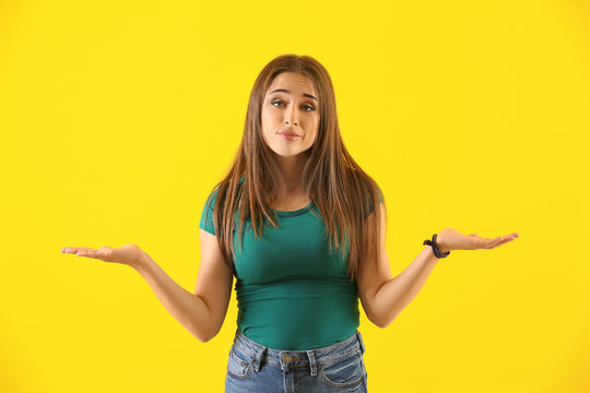 Emotional young woman after making mistake on color background