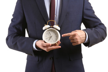 Businessman with alarm clock on white background, closeup