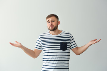Emotional young man after making mistake on white background