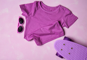 Child t-shirt with sunglasses and skateboard on color background