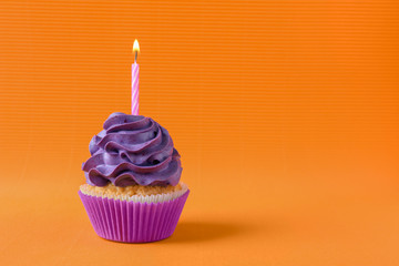 Tasty cupcake with burning candle on color background