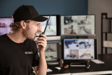 Security guard with portable radio transmitter in surveillance room