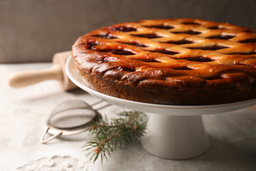 Sweet tasty Christmas pie stuffed with cranberries on table