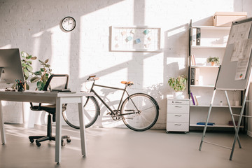 modern office design with flip chart, bicycle and computer desk