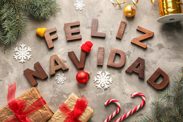 Words FELIZ NAVIDAD made with wooden letters and Christmas decorations on grey background