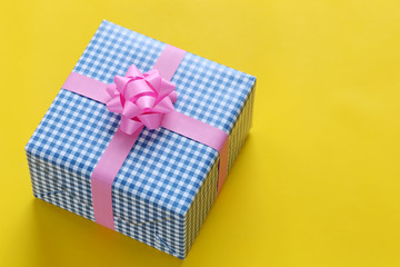 Blue Christmas gift box placed on a yellow art paper floor and have copy space.