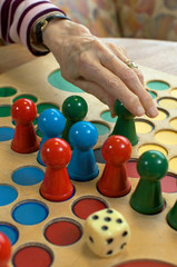 Hand mit Brettspiel und Würfel