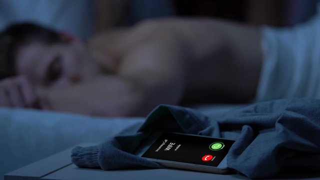 Wife incoming call, husband sleeping on bed after night with mistress, betrayal