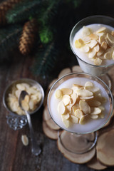 New Year's dessert. Almond milk Panna cotta with almond petals and fir branch