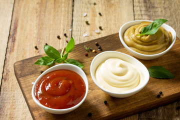 Set of sauces - ketchup, mayonnaise and mustard  sauce on a wooden table. Copy space.